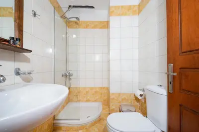 a bathroom with a white sink and a toilet at 4-bedroom Topolia House in Topólia