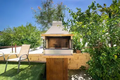 a bird house on a wooden stand in a yard at 4-bedroom Topolia House in Topólia