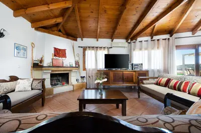 a living room with couches and a flat screen tv at 4-bedroom Topolia House in Topólia