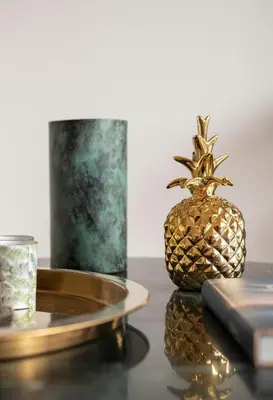 a pineapple on a table with a candle and a glass at Villa Kambos Platanias in Plataniás