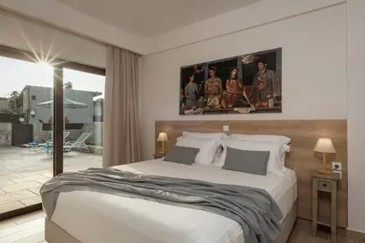 a bedroom with a large bed and a balcony at Villa Kambos Platanias in Plataniás