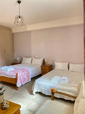 a bedroom with two beds and a couch at Villa Pandora - Petit Bonheur in Maleme