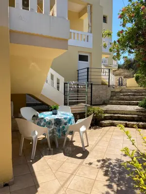 a patio with a table and chairs and stairs at Villa Pandora - Petit Bonheur in Maleme
