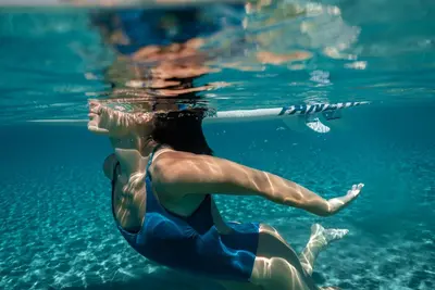 a woman is swimming in the water at Serenity Hideaway in Palaiochóra