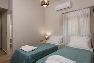 two beds in a small room with a window at Aequor Luxury Rooms & Apartments in Kato Daratso