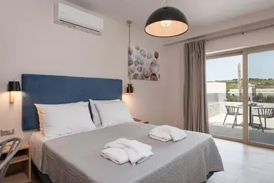 a bedroom with a bed with two towels on it at Aequor Luxury Rooms & Apartments in Kato Daratso