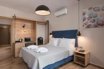 a bedroom with a bed with two pillows on it at Aequor Luxury Rooms & Apartments in Kato Daratso
