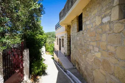 a stone building with a gate next to a street at Topolia 1 Bedroom Villa in Topólia