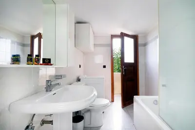 a white bathroom with a sink and a toilet at Topolia 1 Bedroom Villa in Topólia