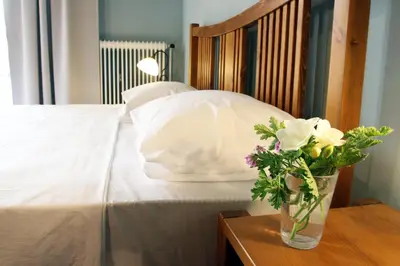 a bed with a vase of flowers on a table at Spacious townhouse close to Chania center in Chania Town