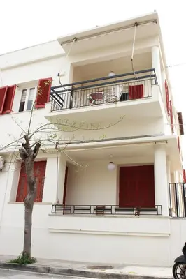 a white house with a tree in front of it at Spacious townhouse close to Chania center in Chania Town