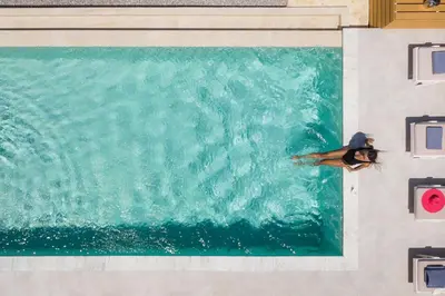 a person swimming in a swimming pool at Villa White Harmony in Khámbatha