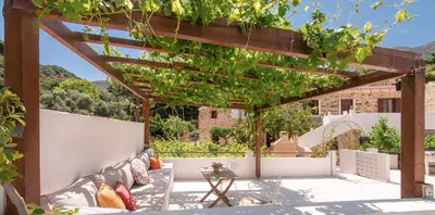 an outdoor patio with a pergola and a table at Feneri- cozy Apartment 20' from Elafonisi beach in Elafonisi