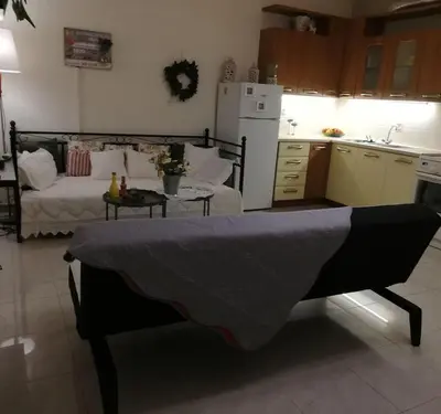 a living room with a bed and a kitchen at Diamant's Place with Treehouse Garden in Kounoupidhianá