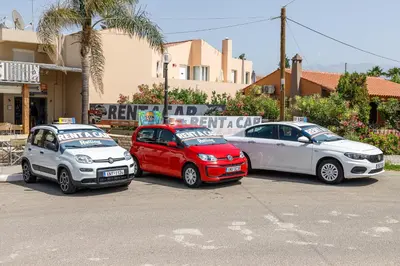 three cars are parked in a parking lot at Sun Beach Apartments in Kato Daratso