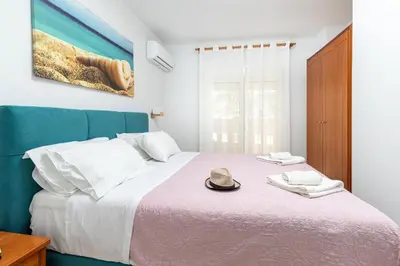 a bedroom with a bed with a hat on it at Sun Beach Apartments in Kato Daratso