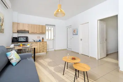 a living room with a couch and a table at Sun Beach Apartments in Kato Daratso