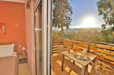 a bedroom with a table and a balcony with a view at Stelios & Stavros Apartment in Kissamos