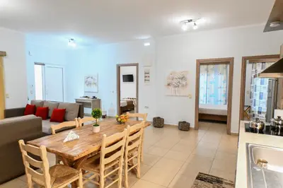 a dining room and living room with a table and a couch at Stelios & Stavros Apartment in Kissamos