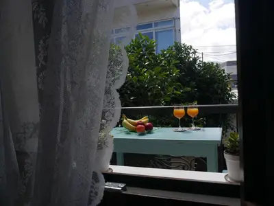a balcony with two glasses of juice and fruit on a table at Agalide in Kissamos
