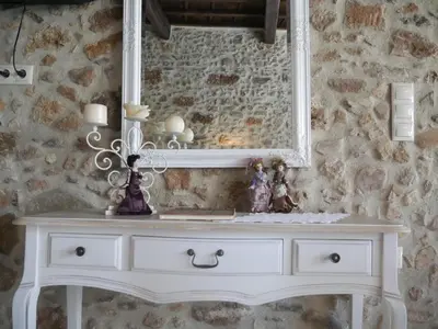 a white dresser with a mirror on a stone wall at Agalide in Kissamos