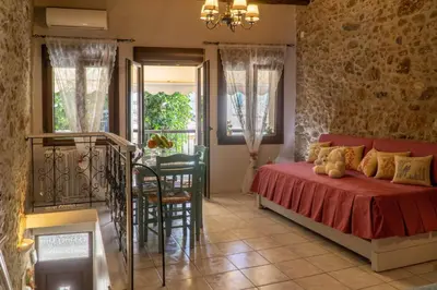 a bedroom with a bed and a table and chairs at Agalide in Kissamos