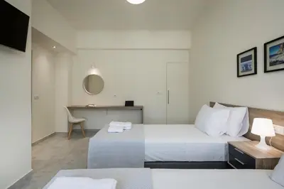 a hotel room with two beds and a desk at Casa Di Xenia in Chania Town
