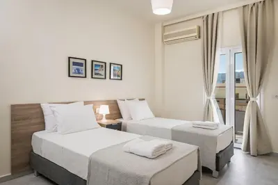 a hotel room with two beds and a window at Casa Di Xenia in Chania Town