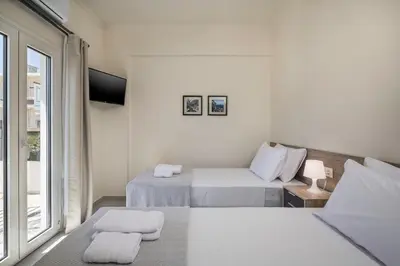 a white room with two beds and a window at Casa Di Xenia in Chania Town