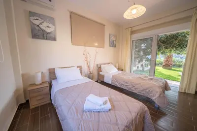 a bedroom with two beds and a window at Meliades Villas in Agia Marina Nea Kydonias