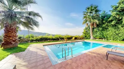 a swimming pool in a yard with palm trees at Meliades Villas in Agia Marina Nea Kydonias