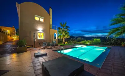 a villa with a swimming pool at night at Meliades Villas in Agia Marina Nea Kydonias