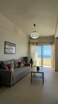 a living room with a couch and a table at Lily of Crete 1 - Sea & Beach front Apartment in Kalamaki Chanion