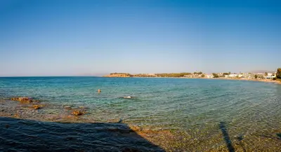 a beach with people swimming in the water at Lily of Crete 1 - Sea & Beach front Apartment in Kalamaki Chanion