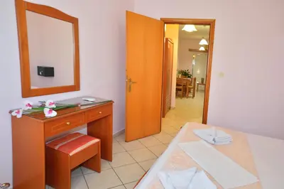 a room with a vanity with a mirror and a table at Villa Mimagia Apartments in Palaiochóra