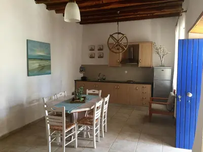 a kitchen and dining room with a table and chairs at Villa Niki in Loutro