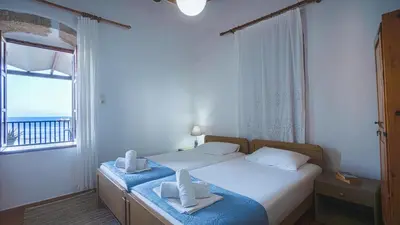 a bedroom with a bed and a large window at Villa Niki in Loutro