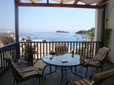 a balcony with a table and chairs and a view of the ocean at Villa Niki in Loutro