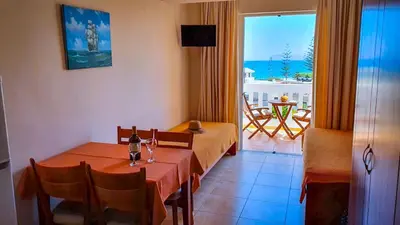 a dining room with a table and a view of the ocean at Kalimera Hotel in Agia Marina Nea Kydonias