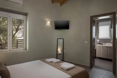 a bedroom with a bed and a television on the wall at Villa Roxanne in Galatás