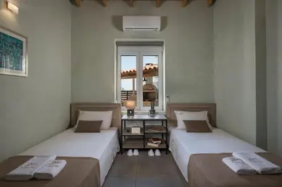 two beds in a room with a window at Villa Roxanne in Galatás