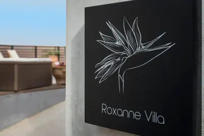 a sign for a villa with a flower on it at Villa Roxanne in Galatás