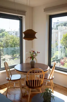 a dining room with a table and chairs and windows at MV Living - Retreat in Daratso