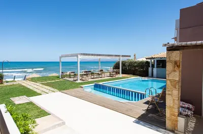 a swimming pool with a view of the ocean at The Mini Beach Hotel in Stalos