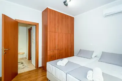 a bedroom with a large white bed and a wooden cabinet at Apartment A80 in Chania Town
