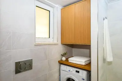 a laundry room with a washing machine and a window at Apartment A80 in Chania Town