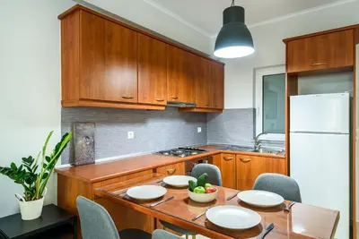 a kitchen with a table with chairs and a white refrigerator at Apartment A80 in Chania Town