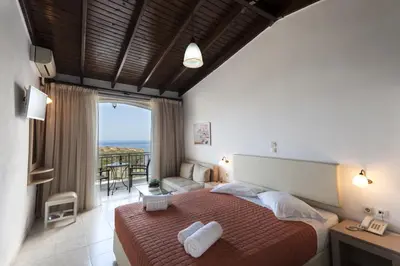 a bedroom with a bed and a view of the ocean at Frida Apartments in Chania Town