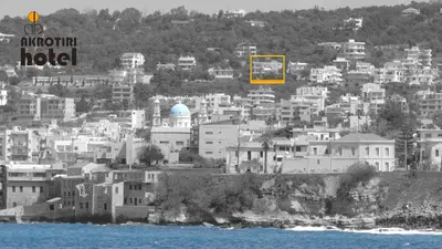 a group of buildings on a hill next to the water at Akrotiri Hotel in Chania Town
