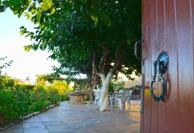 a house door with a tree and a table and chairs at Kamara Stone House in Kissamos